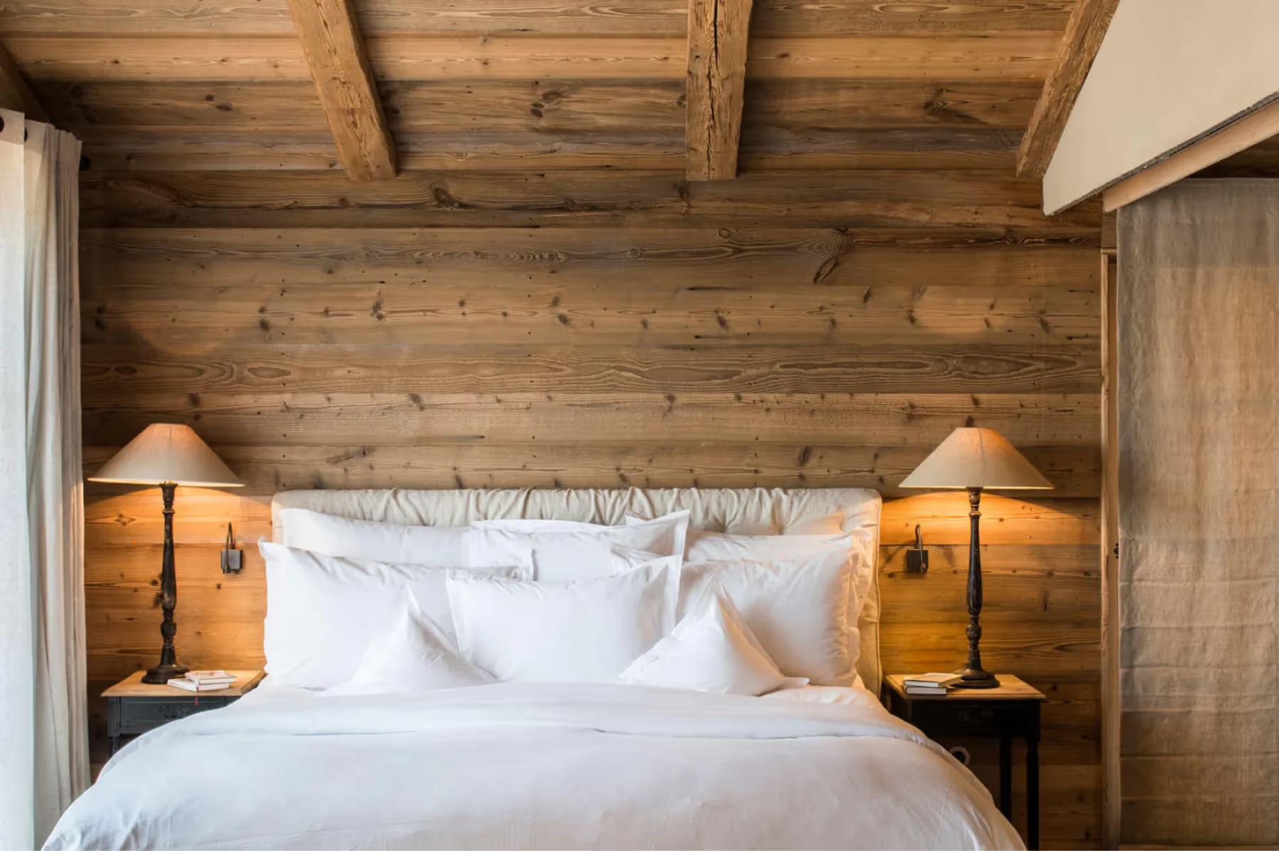 San Luis Retreat: wooden bedroom with exposed beams and a framed headboard with white bedding