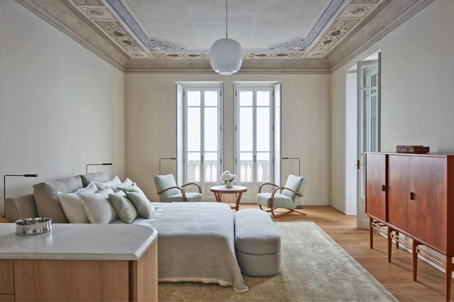 Villa Patrizia: a suite with fresco ceiling detail, white bedding, and French doors to garden