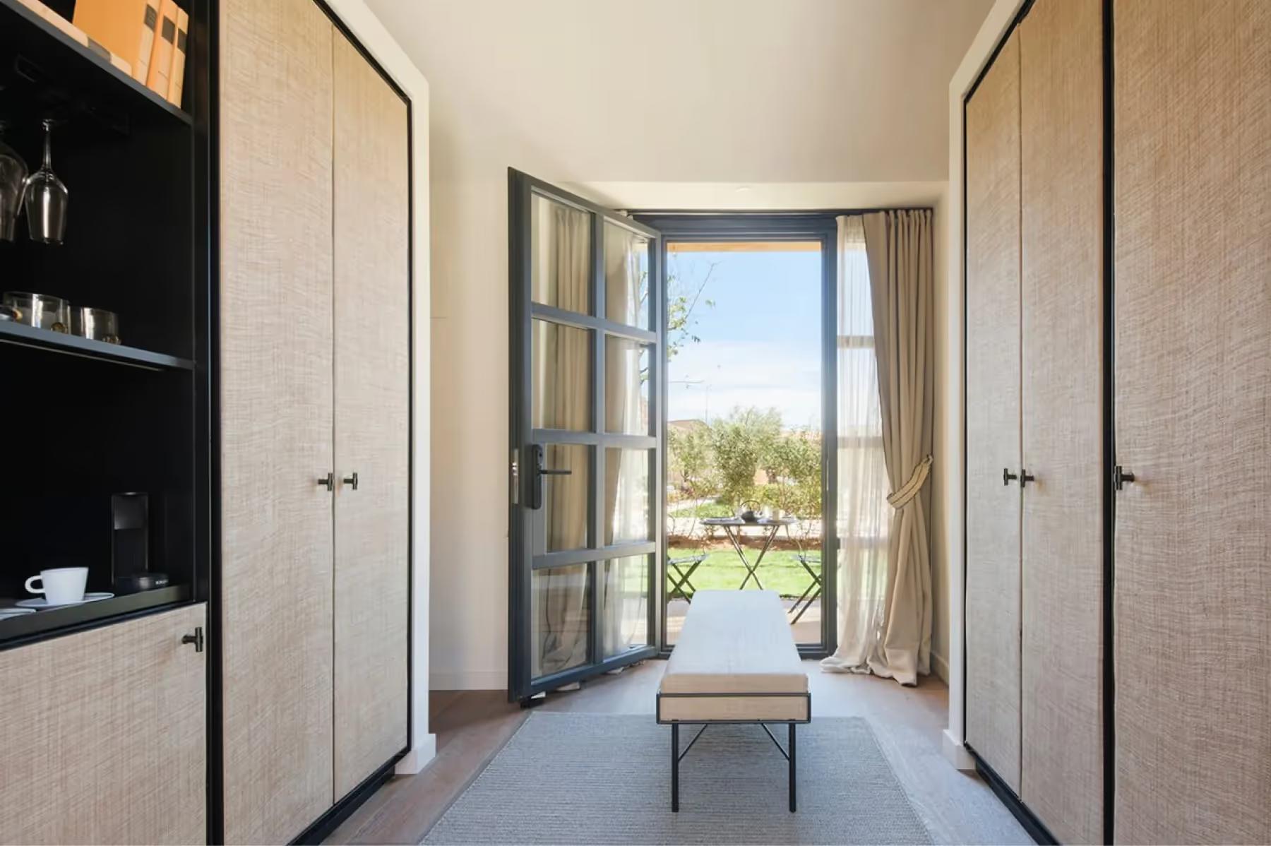 Can Ferrereta: suite with four-poster canopy bed and modern furnishings in soft colors