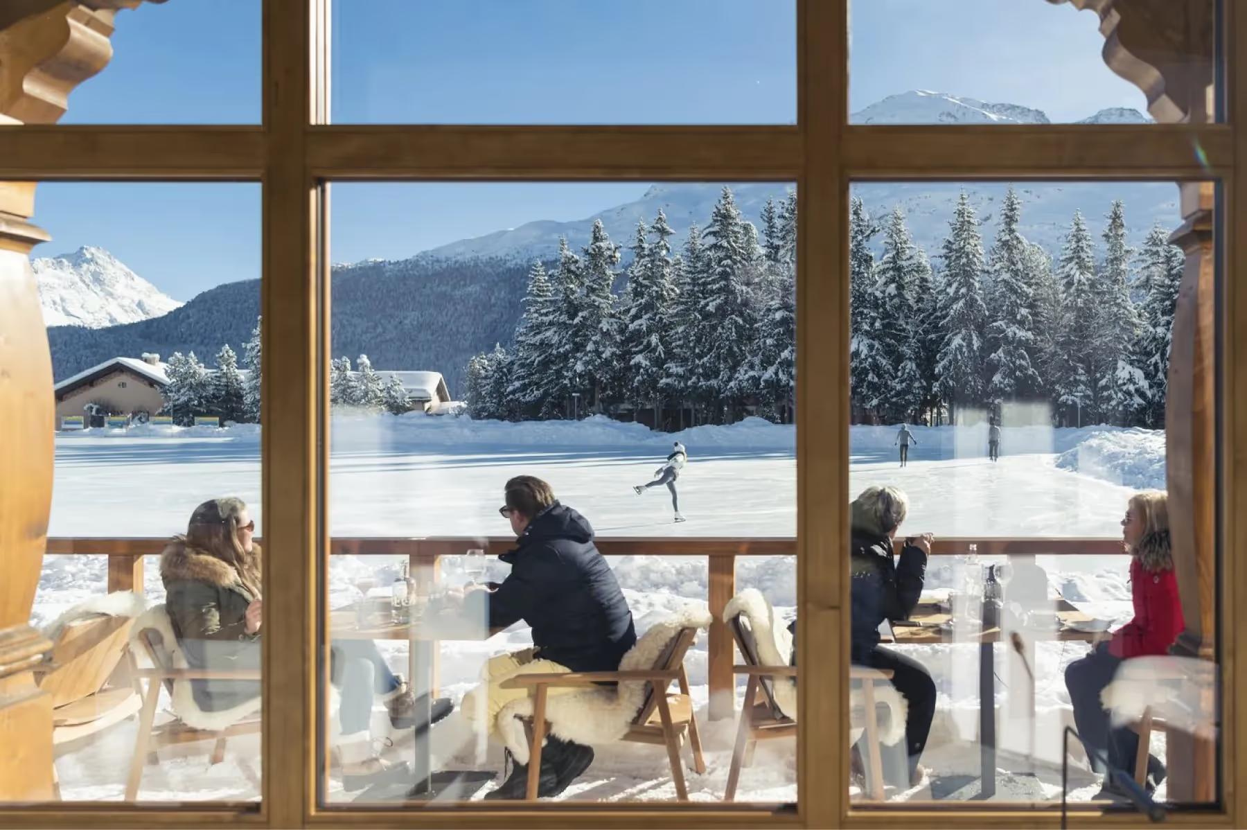 Kulm Hotel St. Moritz: guests enjoy drinks and lakeside views from the hotel’s terrace in winter sunlight