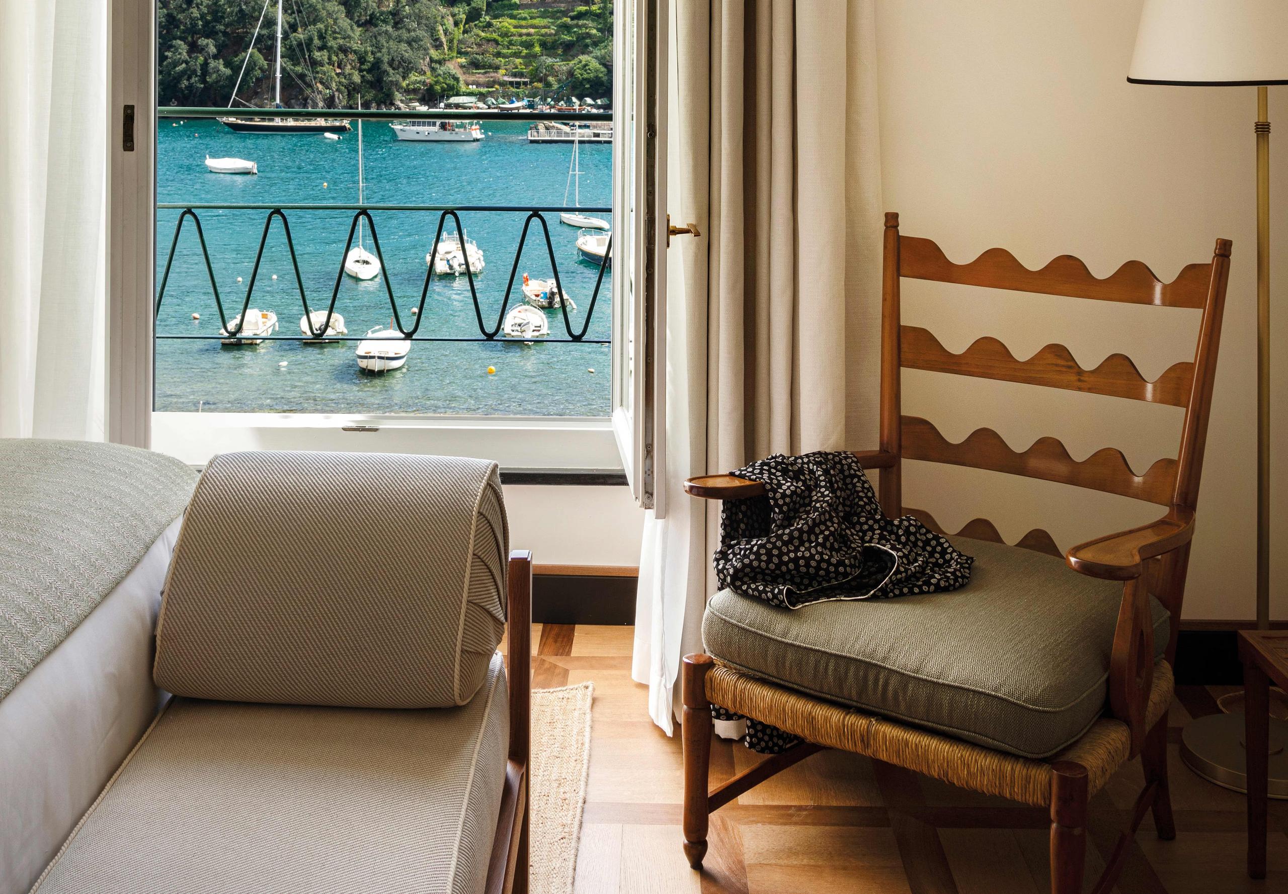 Suite interior with mirror, seating area, and harbor-view balcony
