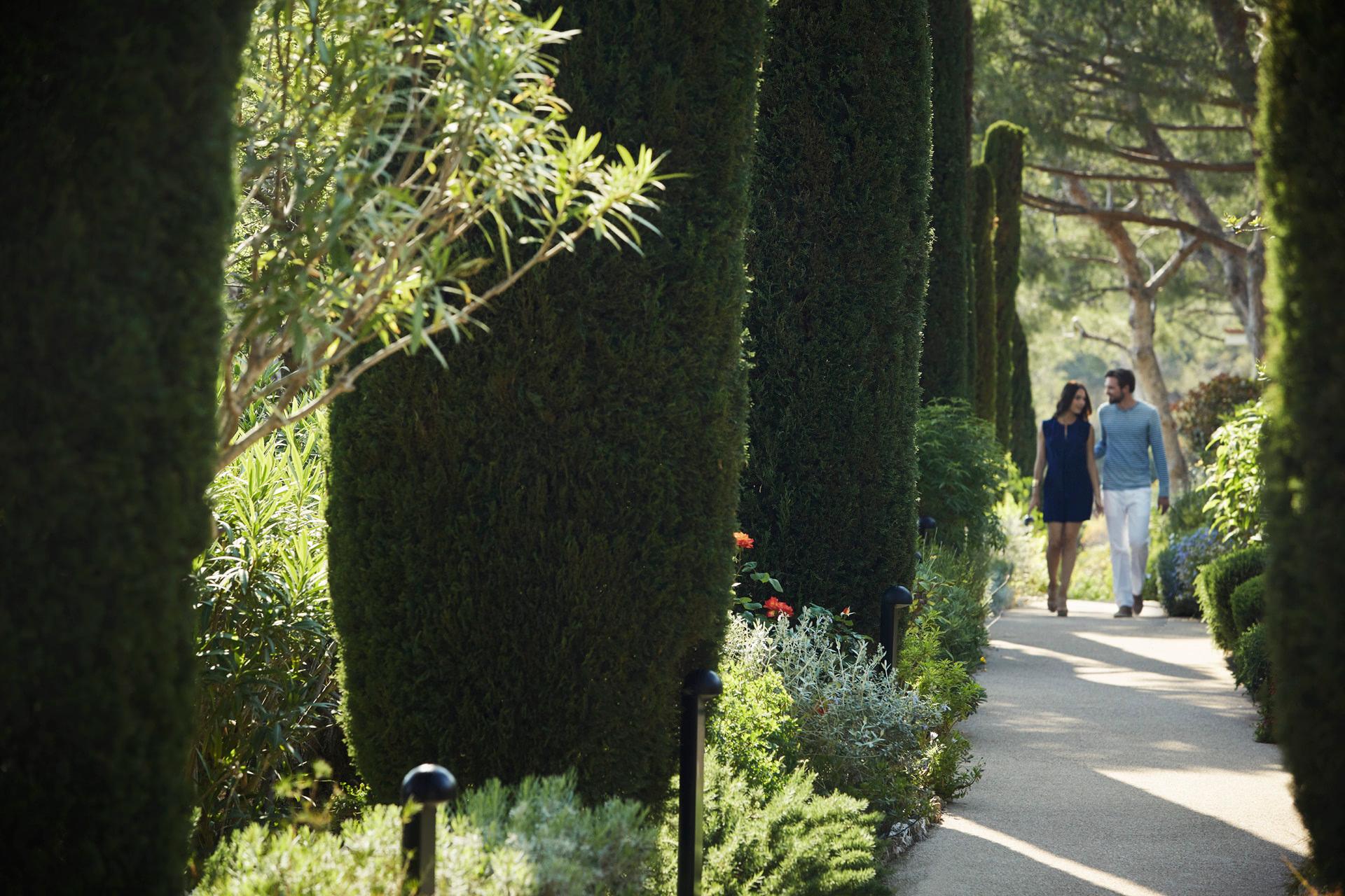 Grand-Hôtel du Cap-Ferrat: cypress-lined garden pathway with filtered light and figures walking