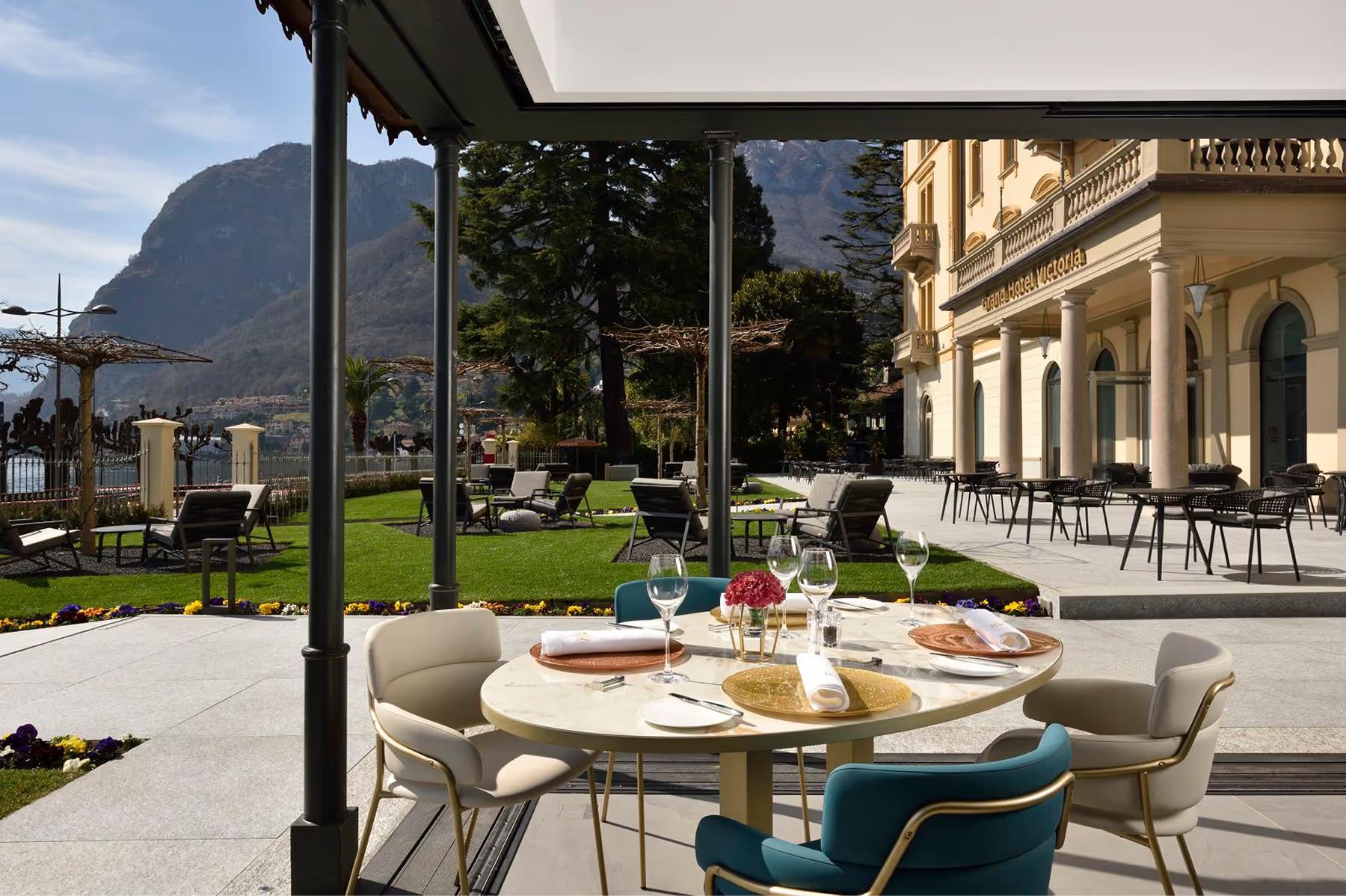 Grand Hotel Victoria Concept & Spa: a modern restaurant interior with tall windows, blue chairs, and natural light