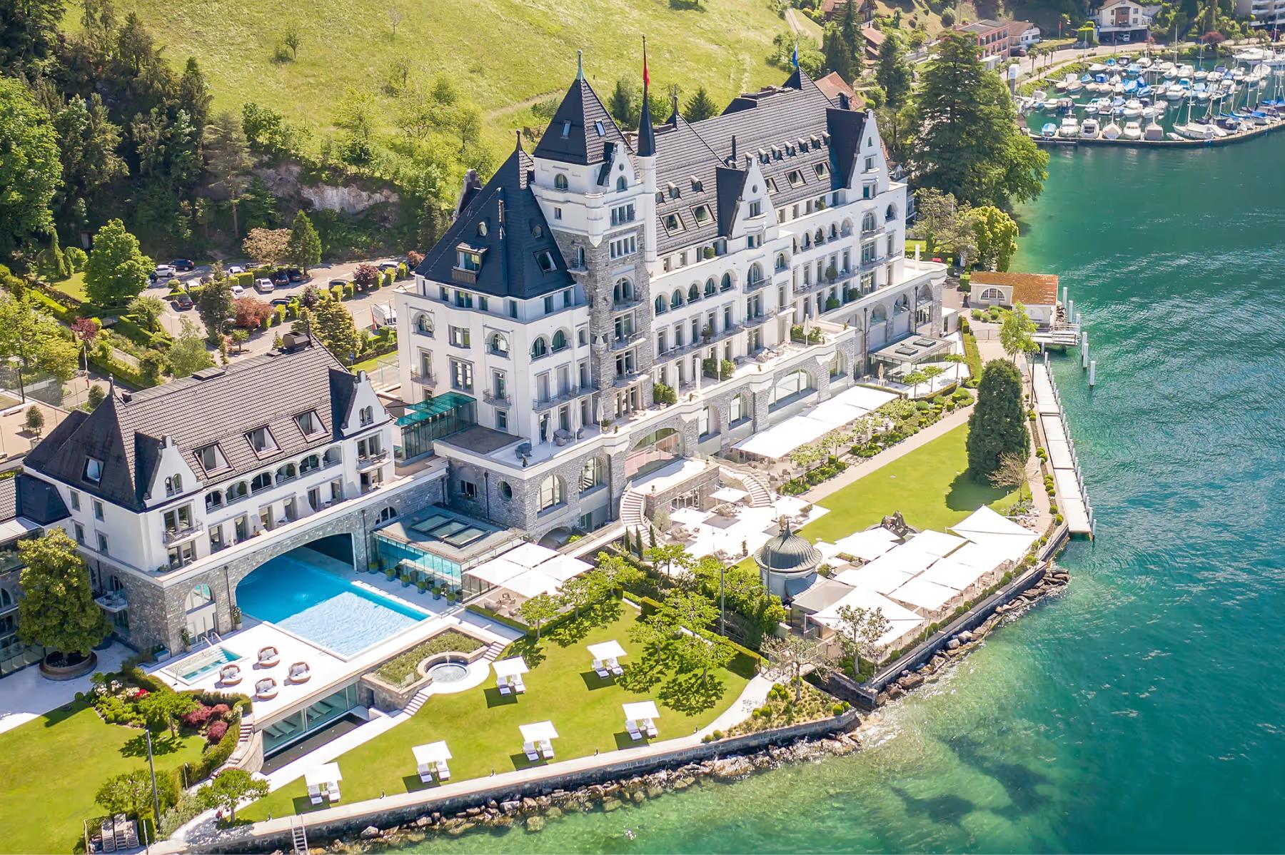 Park Hotel Vitznau: aerial view of the hotel’s white stone structure on the lake with manicured grounds