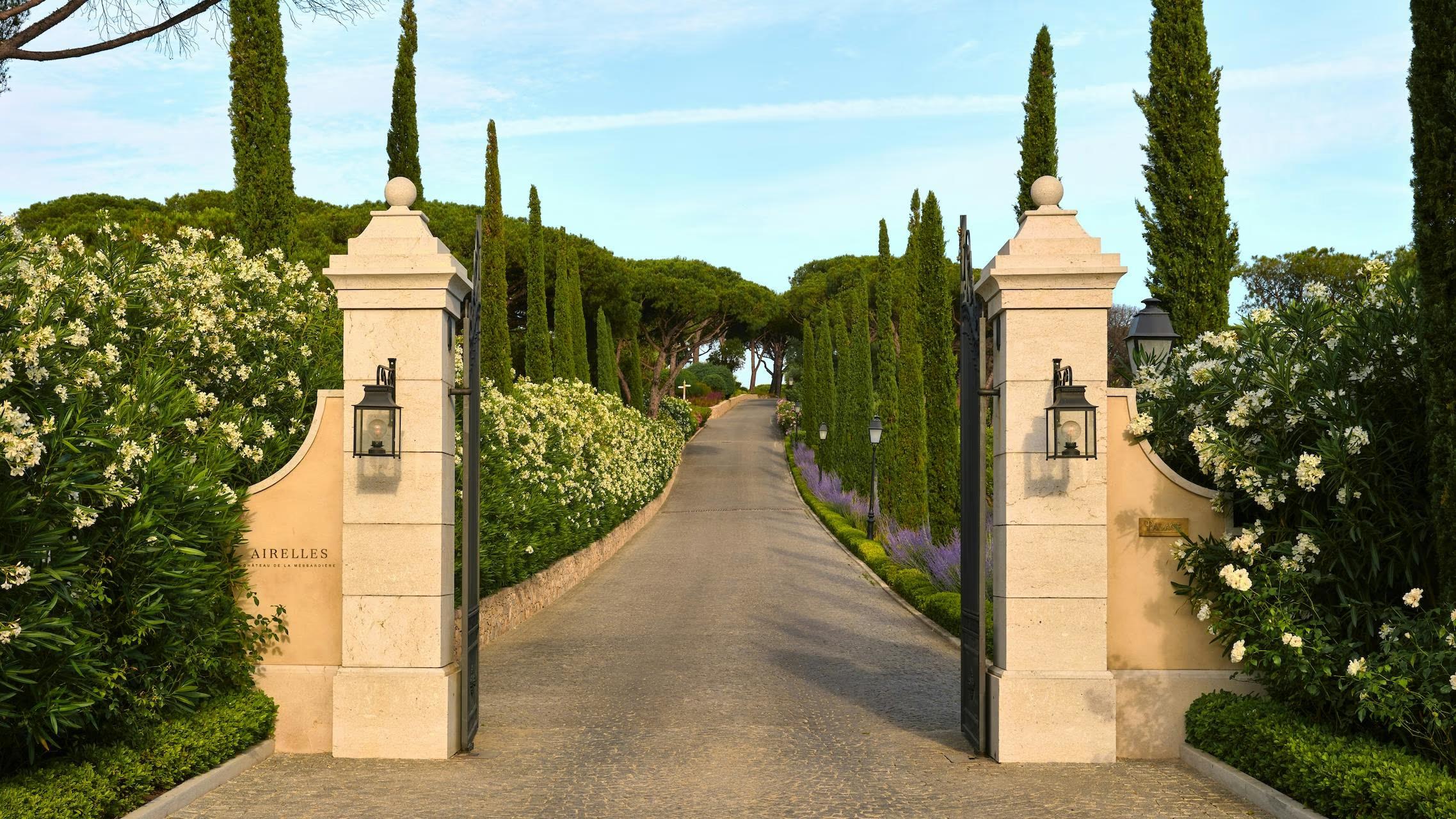 The entrance gates and cypress-lined drive of Château de La Messardière