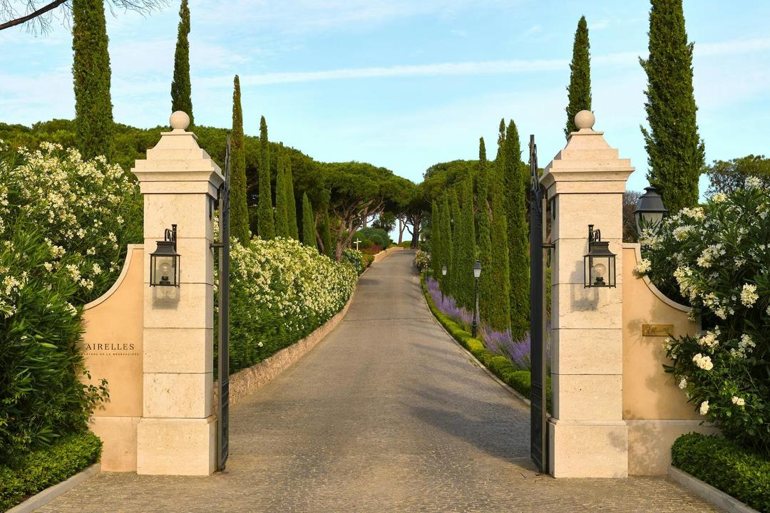 The entrance gates and cypress-lined drive of Château de La Messardière