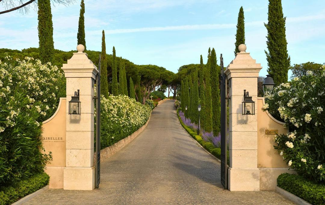 The entrance gates and cypress-lined drive of Château de la Messardière