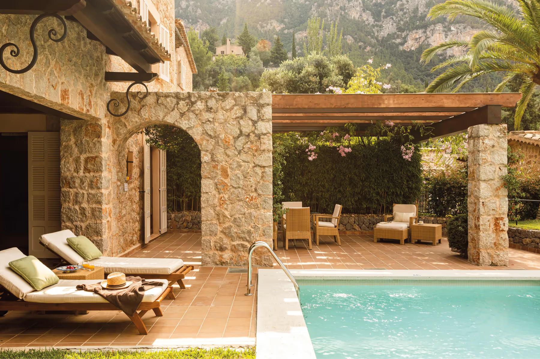 La Residencia: stone villa with private pool, lounge seating, wooden pergola, and Mediterranean hillside setting