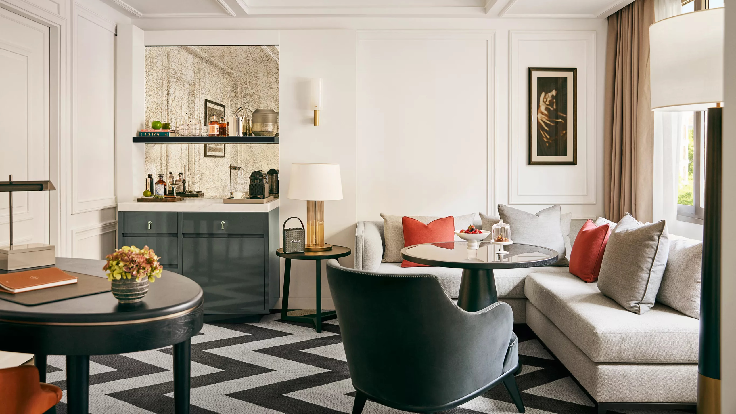 Rosewood Villa Magna: a living room with teal accent chair, neutral sofa, and dark wood furnishings with gold accents