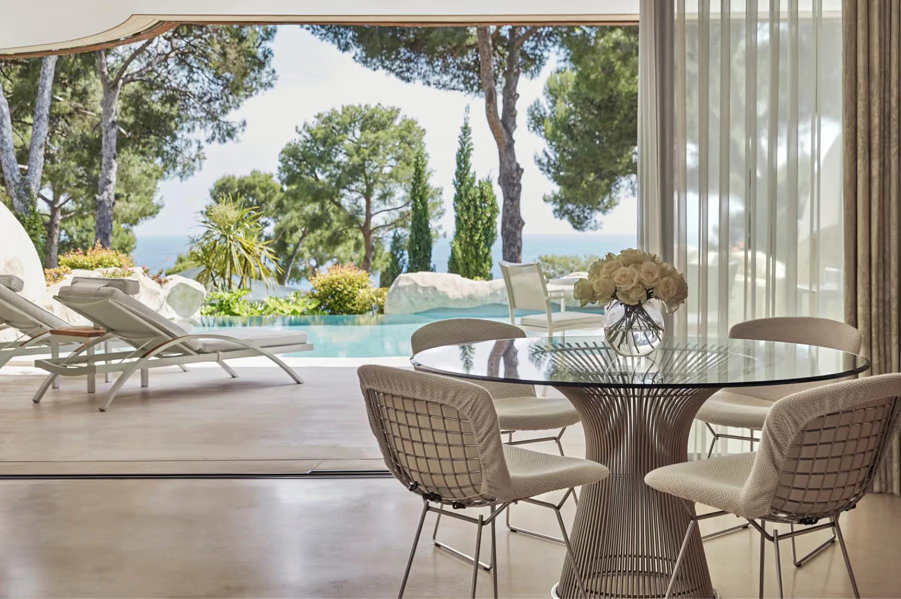 Grand-Hôtel du Cap-Ferrat: furnished terrace with dining table and sea view through open glass doors