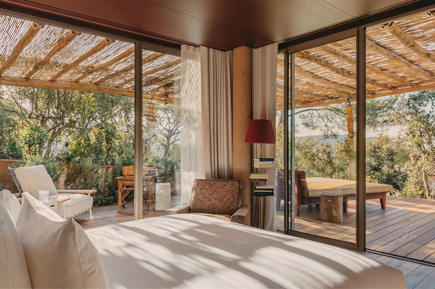 Bedroom with timber ceiling, glass doors, and panoramic landscape view