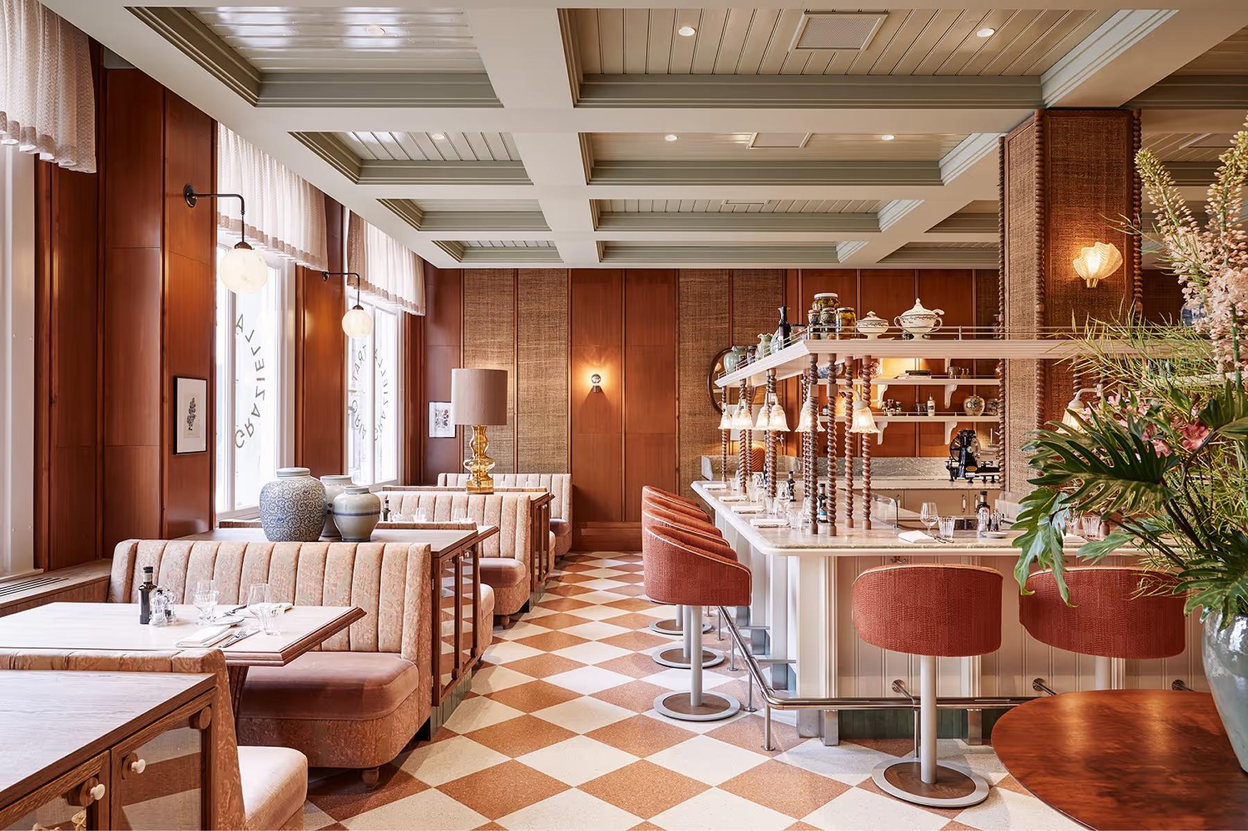 De L’Europe Amsterdam: bar seating area with burgundy paneling, warm lighting, and sophisticated glassware display