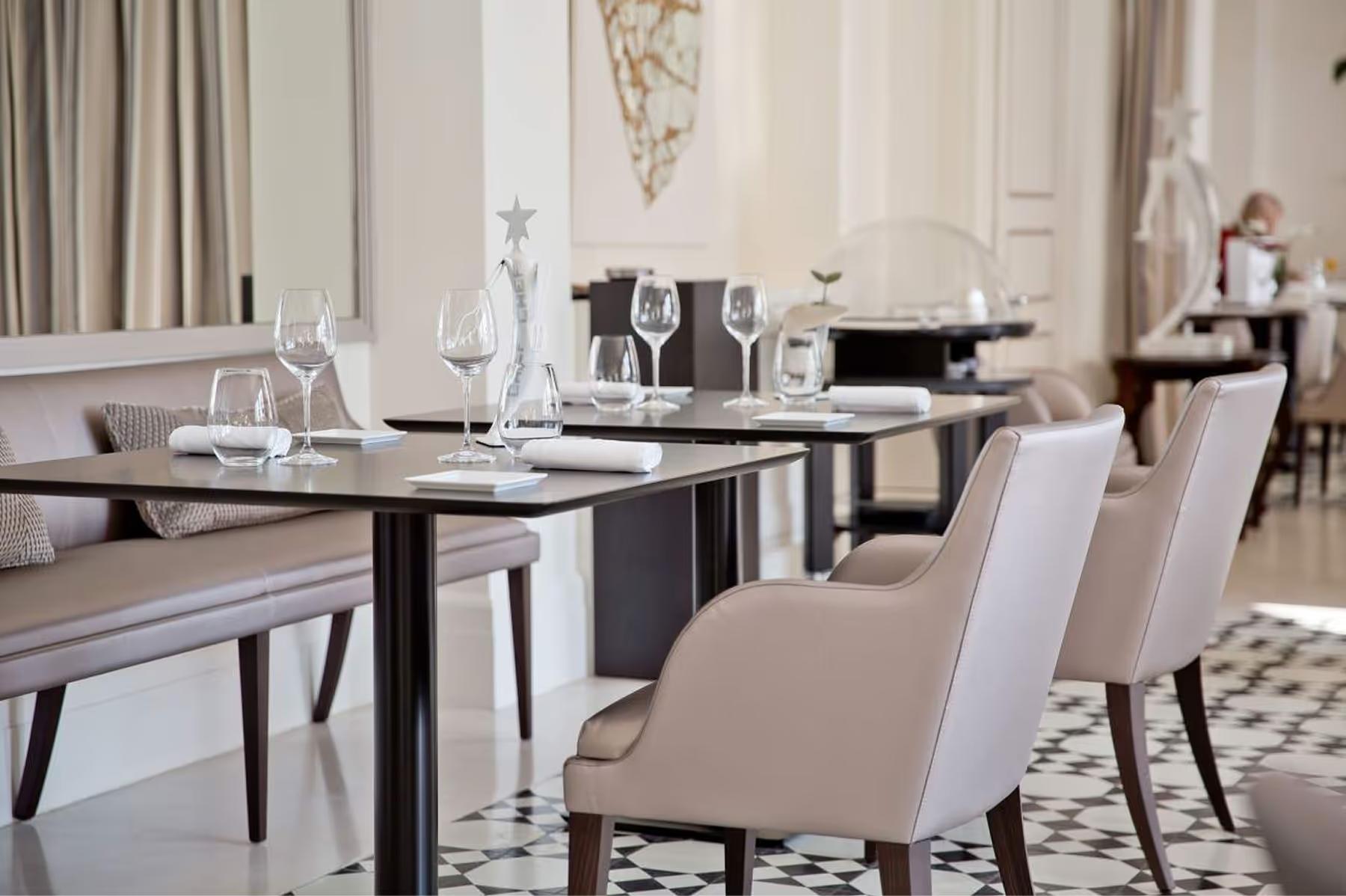Hotel Cap-Estel: a formal dining room with neutral tones and dark wood accents