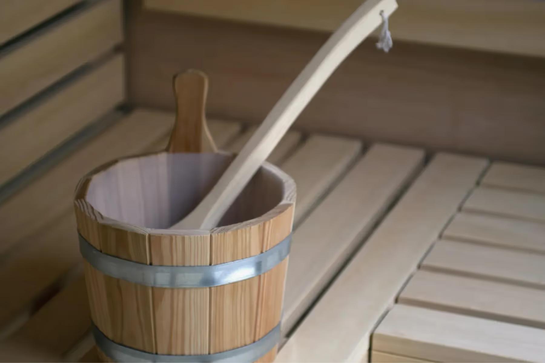 Es Racó d’Artà: wooden sauna bucket with ladle resting on slatted bench seating