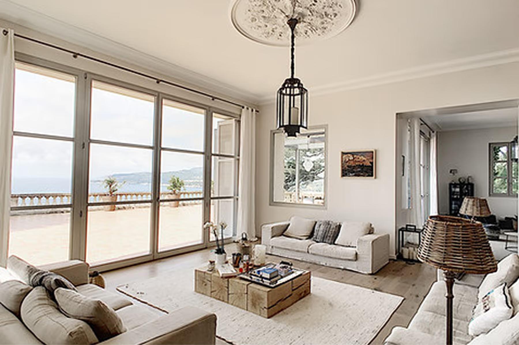 Le Domaine de Canaille: bright living room with modern furnishings, sea views through tall windows, pendant lighting
