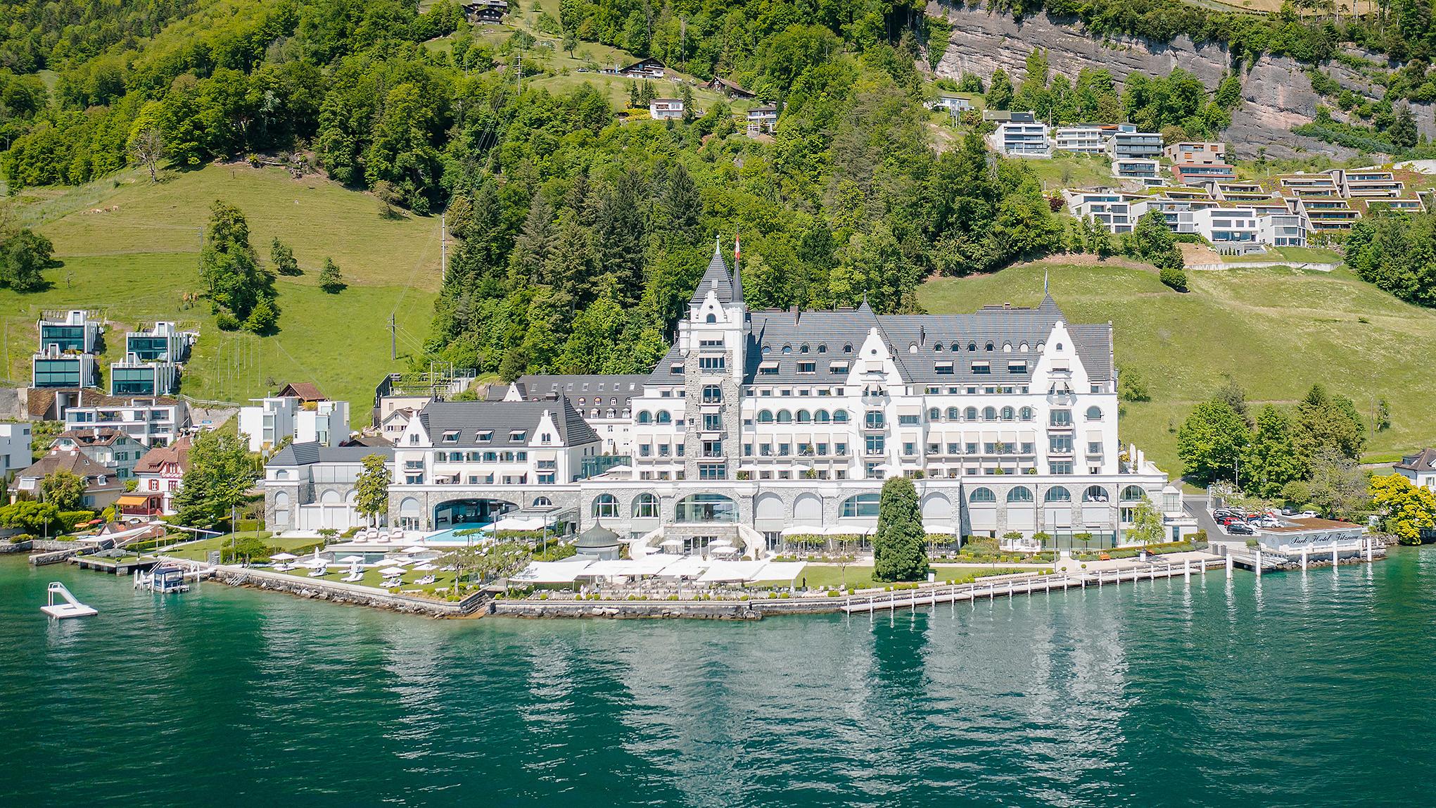 Hotel positioned on the lake with forested hillsides in background