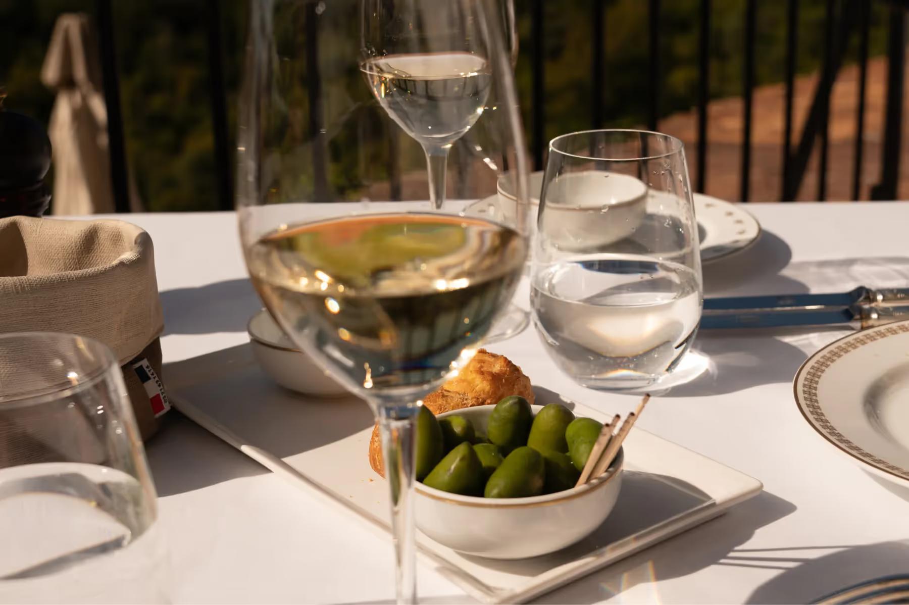 Airelles Gordes, La Bastide: dinner service on white tablecloth with terracotta views beyond the railing
