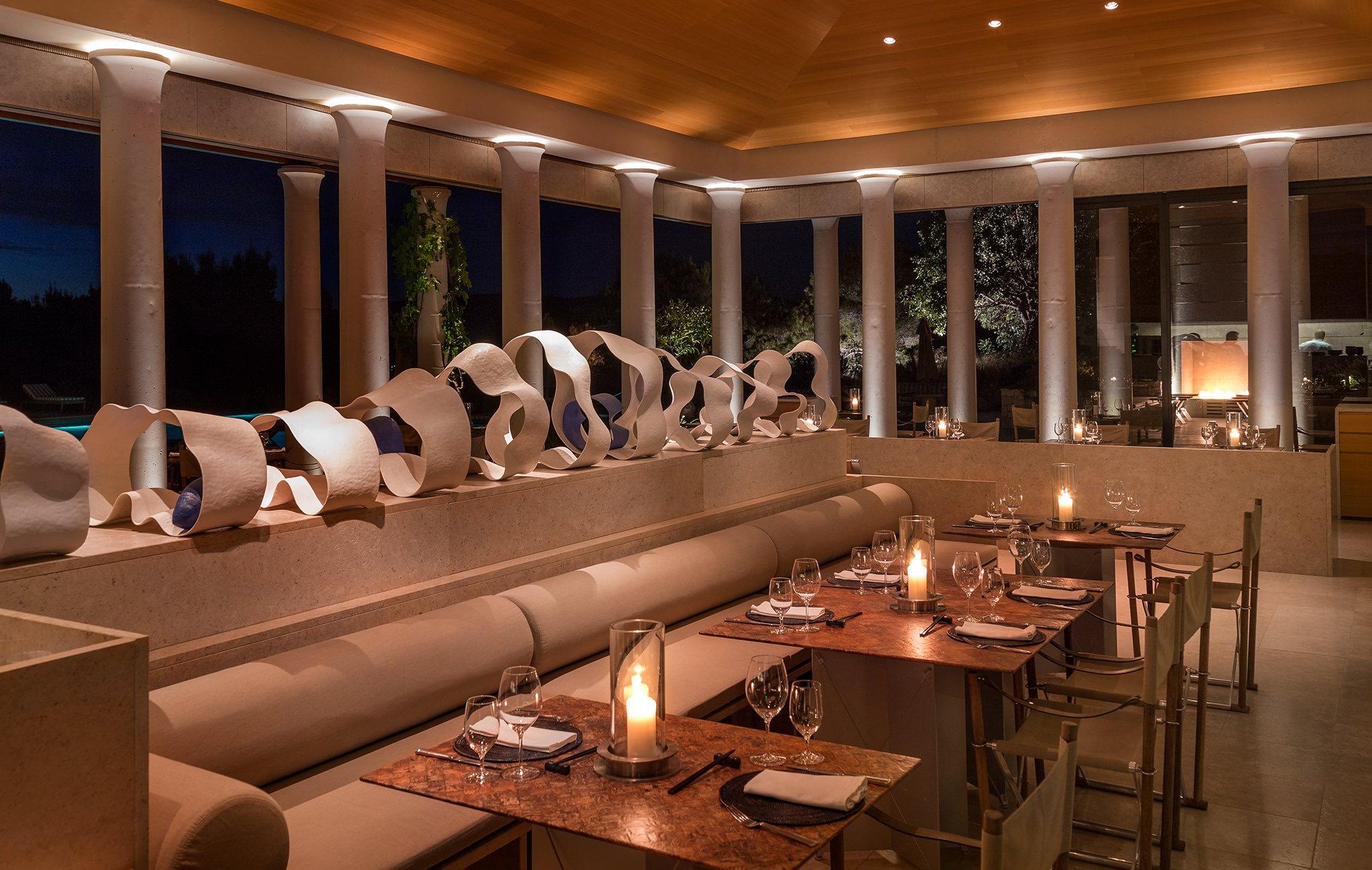 Amanzoe: modern dining room with curved banquette seating and ambient lighting