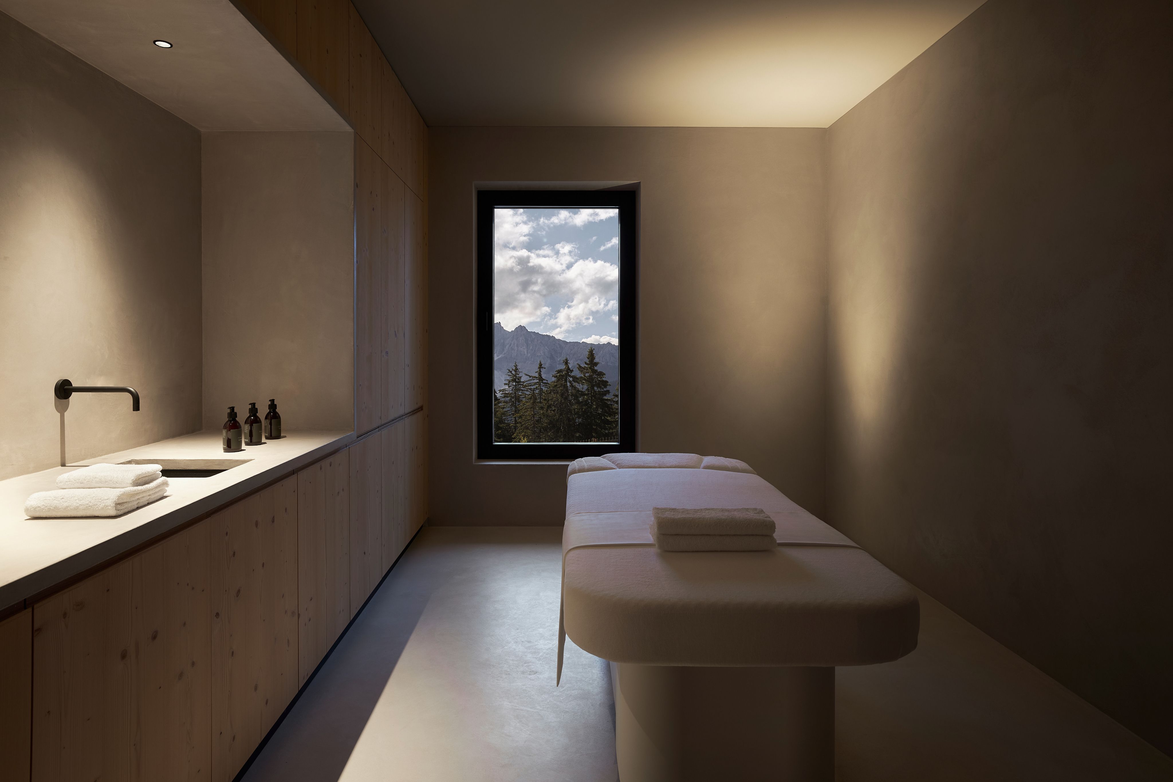 A minimal treatment room at Forestis with a window onto the Dolomites