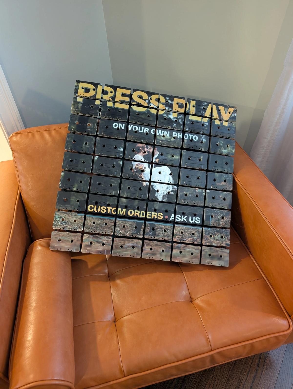 Custom-photo cassette mosaic demonstration resting on an orange chair, showing its overall scale