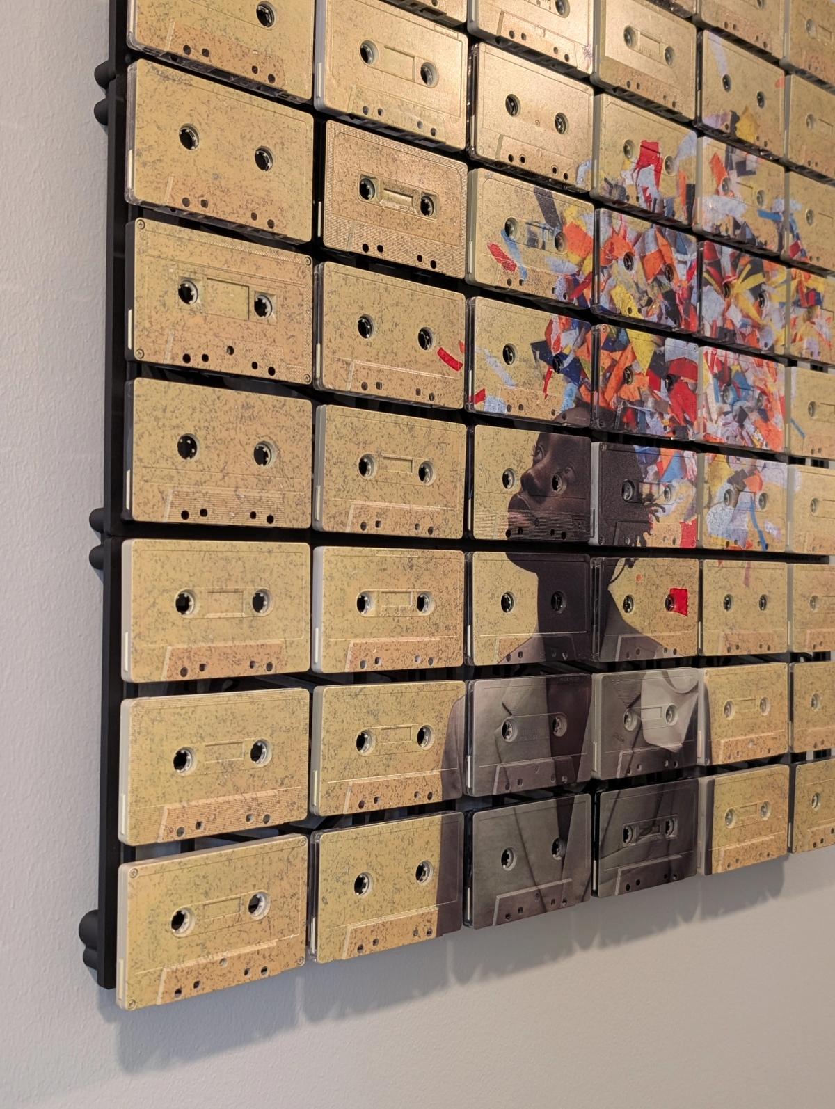 Angled view of a portrait with concentrated colourful artwork and visible pale cassette shells around it