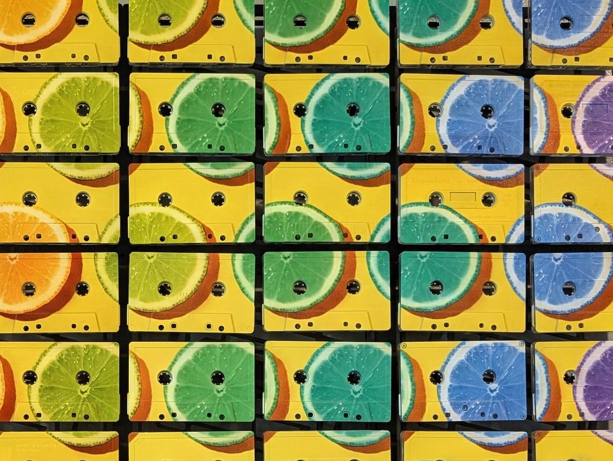 Green, turquoise, and blue citrus slices crossing individual cassette faces and reel openings