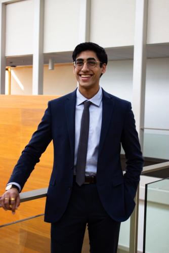 person in suit leaning on railing