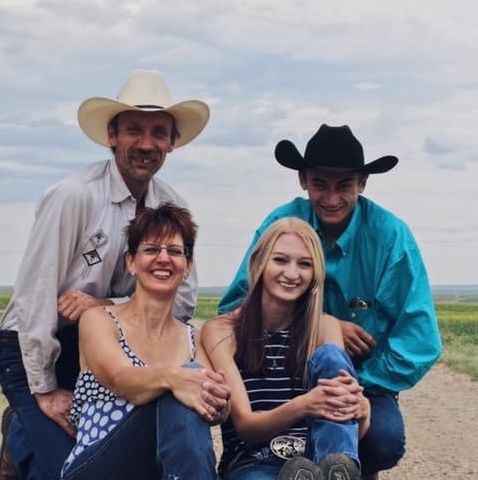 A family sitting together on a dirt road