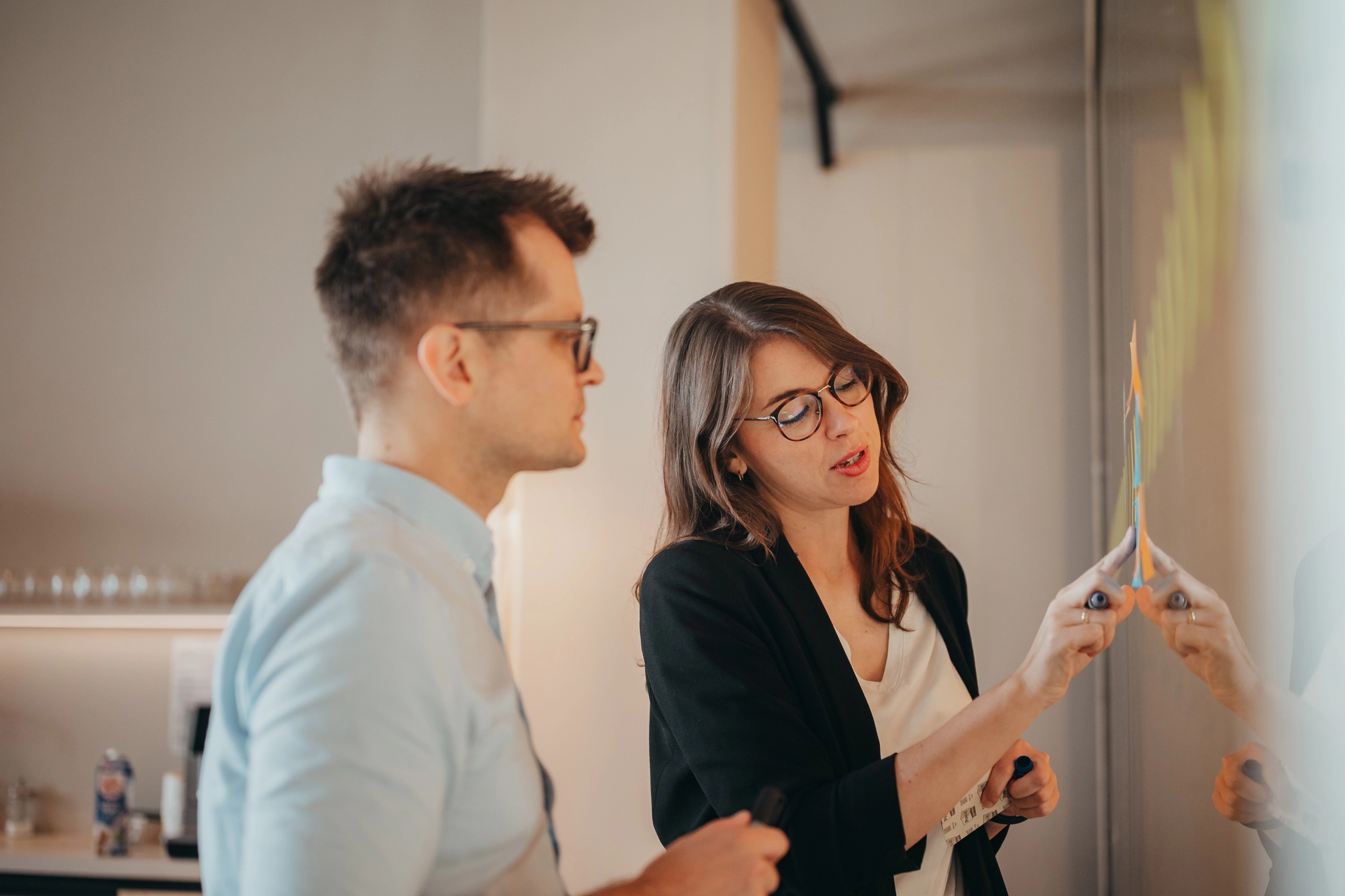 Lars Brendler und Katharina Lutermann, die Gründer von tdlc, stehen vor einer transparenten Scheibe in einem Workshop-Setting im Coppenrath Innovation Centre.