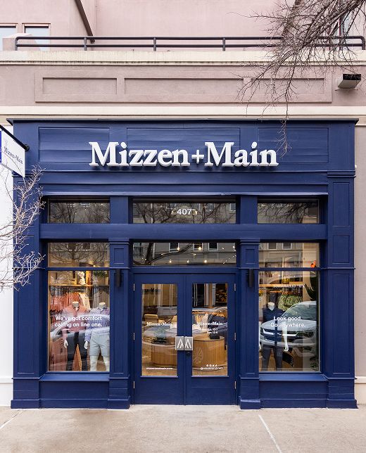 The first Mizzen+Main store: a navy storefront with the brand's name above mannequin-filled display windows.