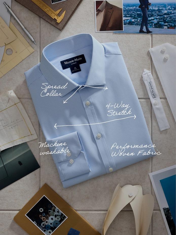 A top-down product flat-lay of a light blue grid dress shirt surrounded by design sketches and photo swatches, with annotations pointing out features like Spread Collar, 4-Way Stretch, Machine Washable, and Performance Woven Fabric.
