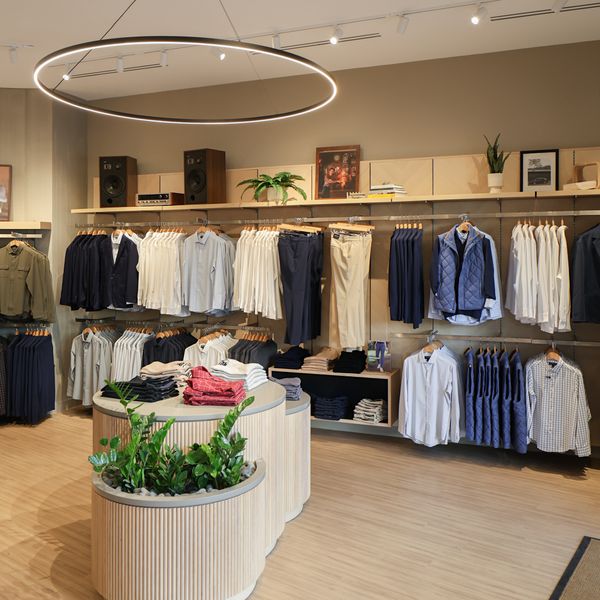 Racks of shirts and pants under a ring light inside the Mizzen+Main La Cantera store