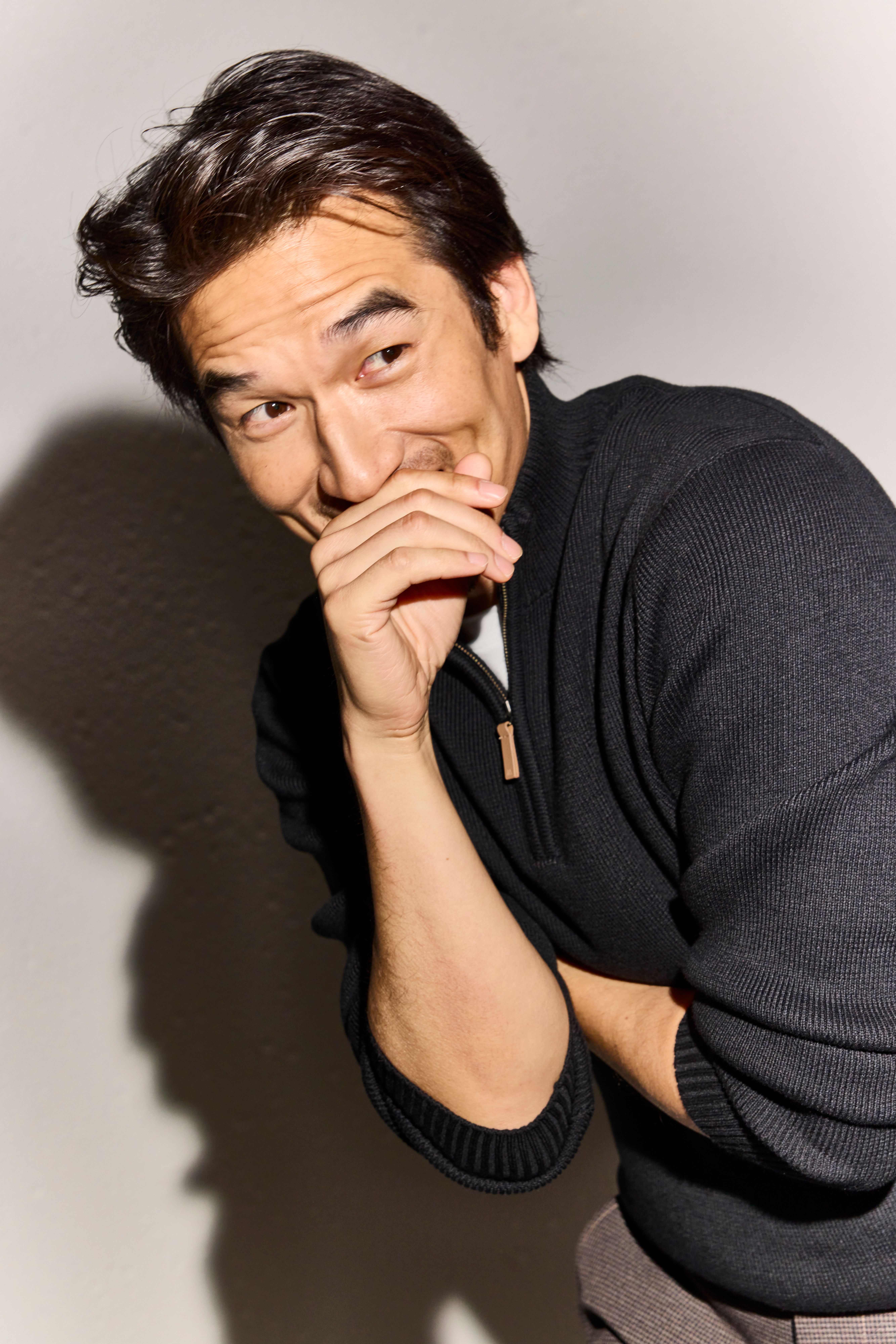Laughing man wearing a black Hillcrest quarter zip sweater