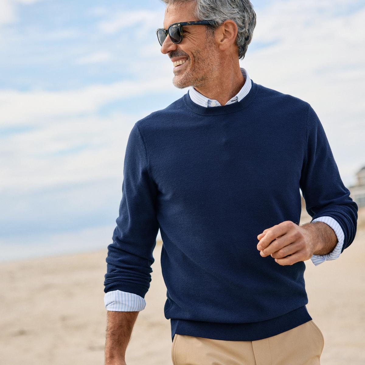 Man relaxing outside wearing the new Heritage sweater.