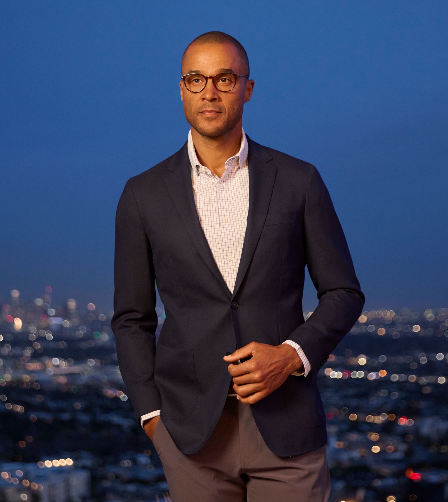 A navy windowpane blazer laid flat, showing its tailoring and pattern detail.