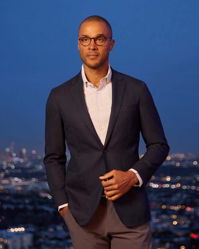 A navy windowpane blazer laid flat, showing its tailoring and pattern detail.