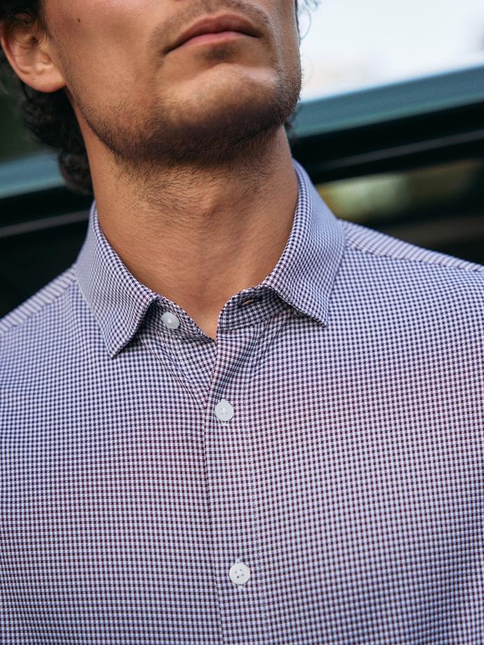 A close-up shot focusing on the collar and pattern of a purple and white micro-check button-down shirt.