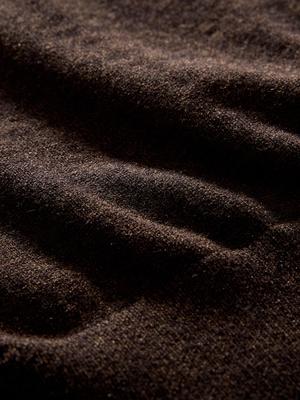 A macro close-up shot of dark brown knit fabric texture with soft lighting.