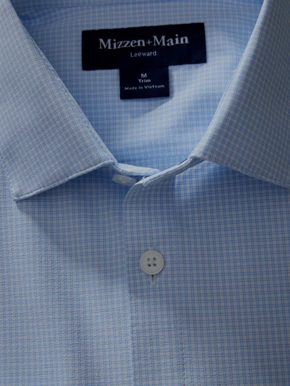 Close-up shot of the collar and collar label of a light blue grid-pattern Mizzen+Main dress shirt.