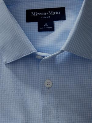 Close-up shot of the collar and collar label of a light blue grid-pattern Mizzen+Main dress shirt.