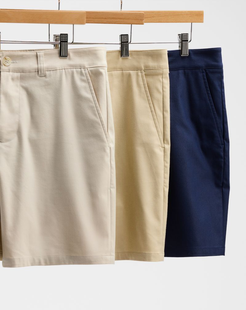 Three Prescott shorts on wooden hangers in stone, khaki and navy