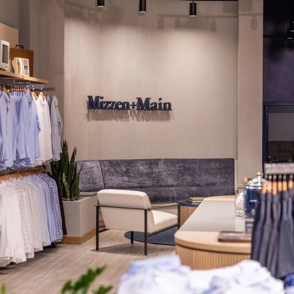 Racks of dress shirts beside the lounge seating in the Mizzen+Main West Village store