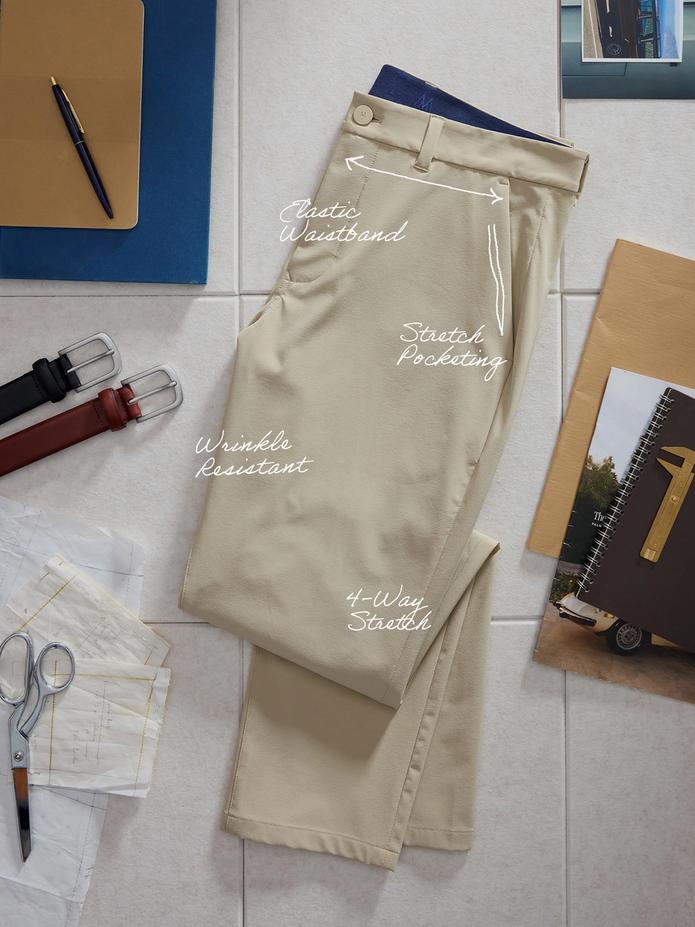 Top-down product flat-lay photo of tan trousers annotated with features like "Elastic Waistband", "Stretch Pocketing", "Wrinkle Resistant", and "4-Way Stretch".