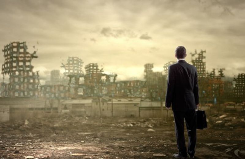worker looking at post ruins of office building