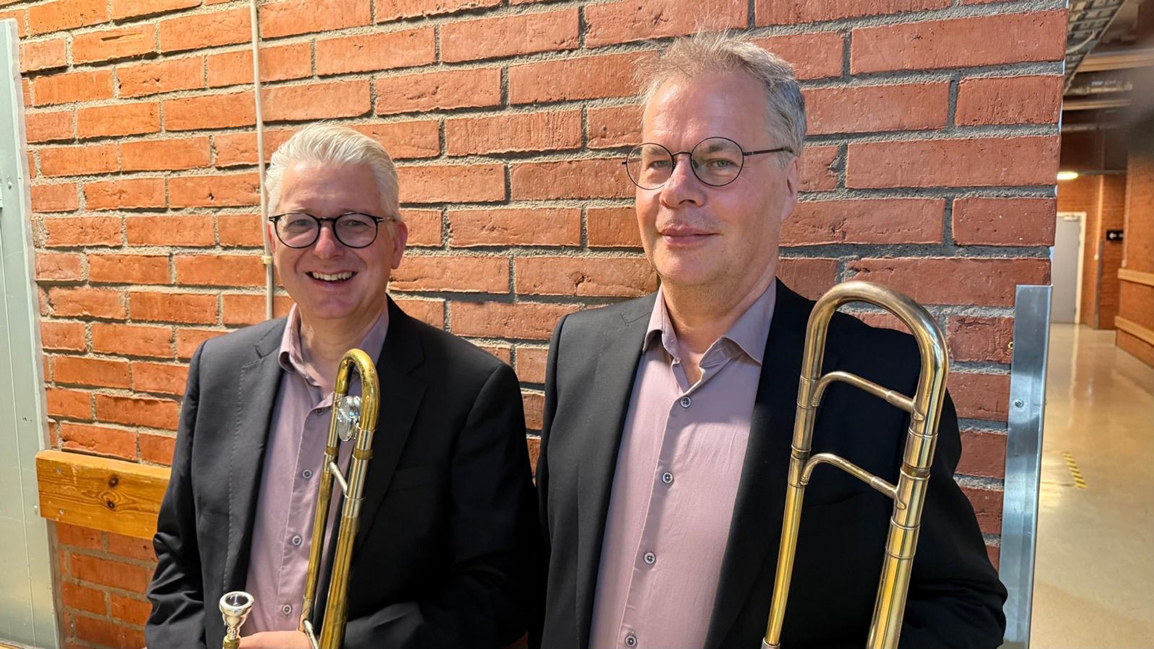 Christer Olofsson och Niclas Rydh står mot en tegelvägg.