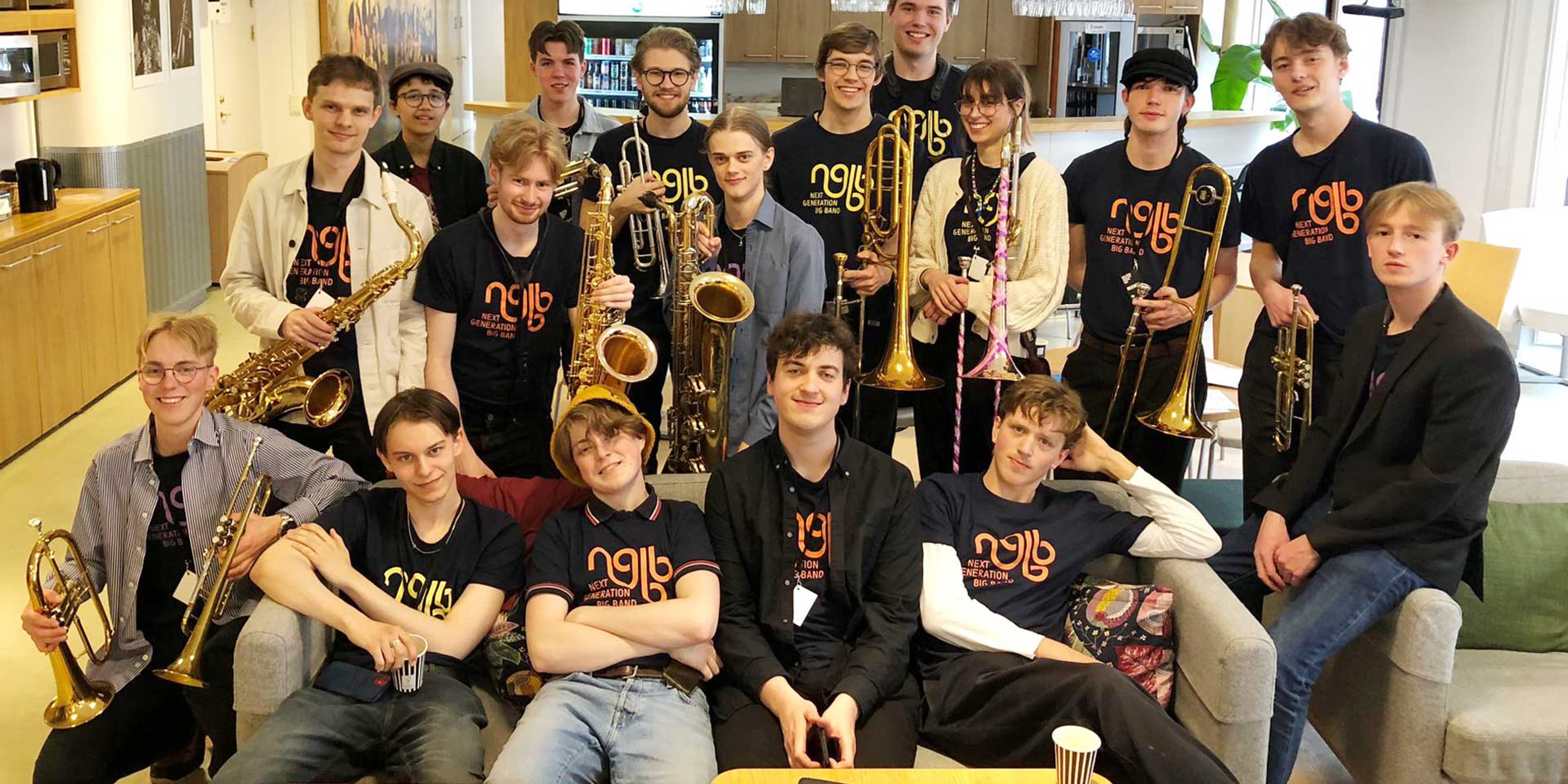 Musiker i Next Generation Big Band sitter i en soffa.