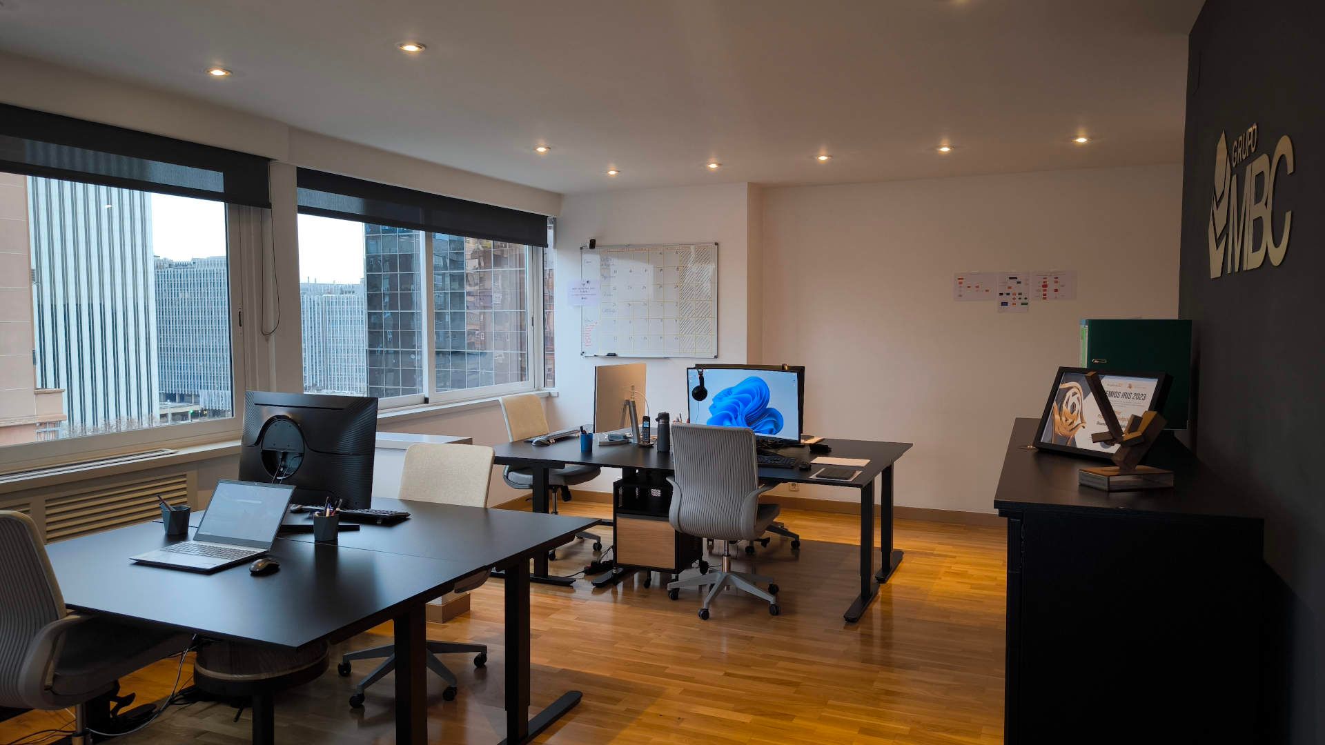 Sala de oficina con varios escritorios y ventanales