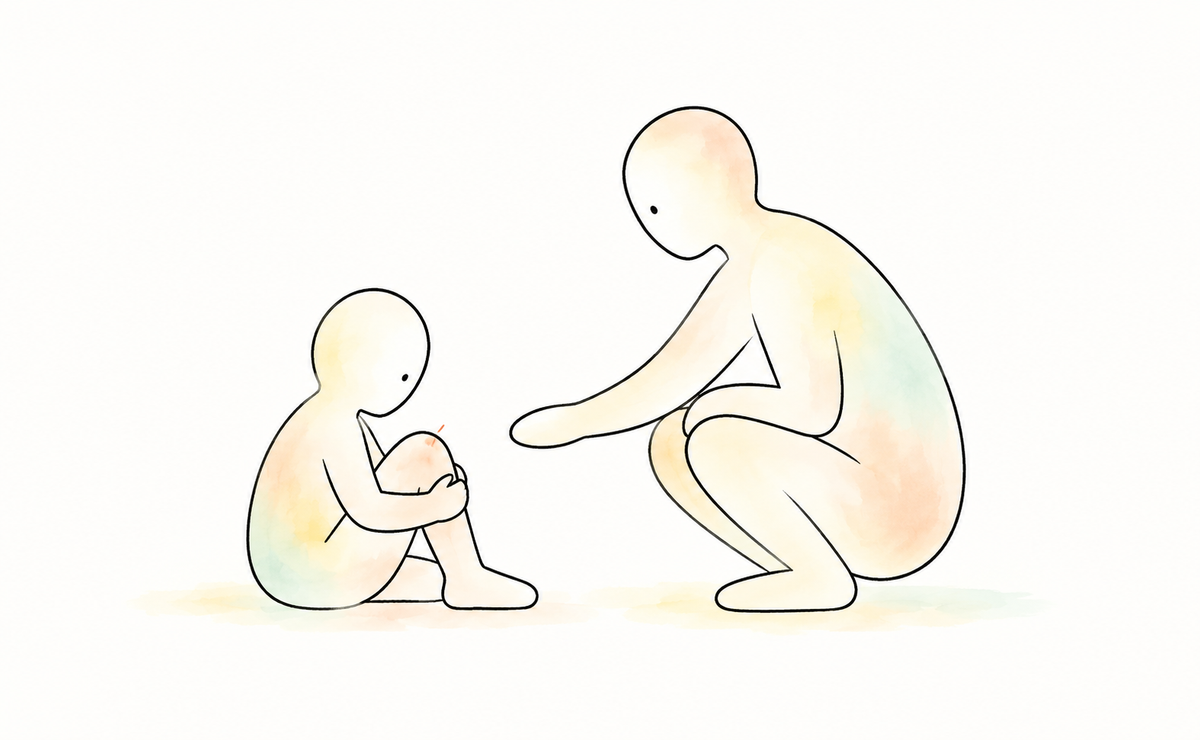 Recognising pain: A child holds a grazed knee while an adult crouches nearby, offering a gentle, open-handed response.