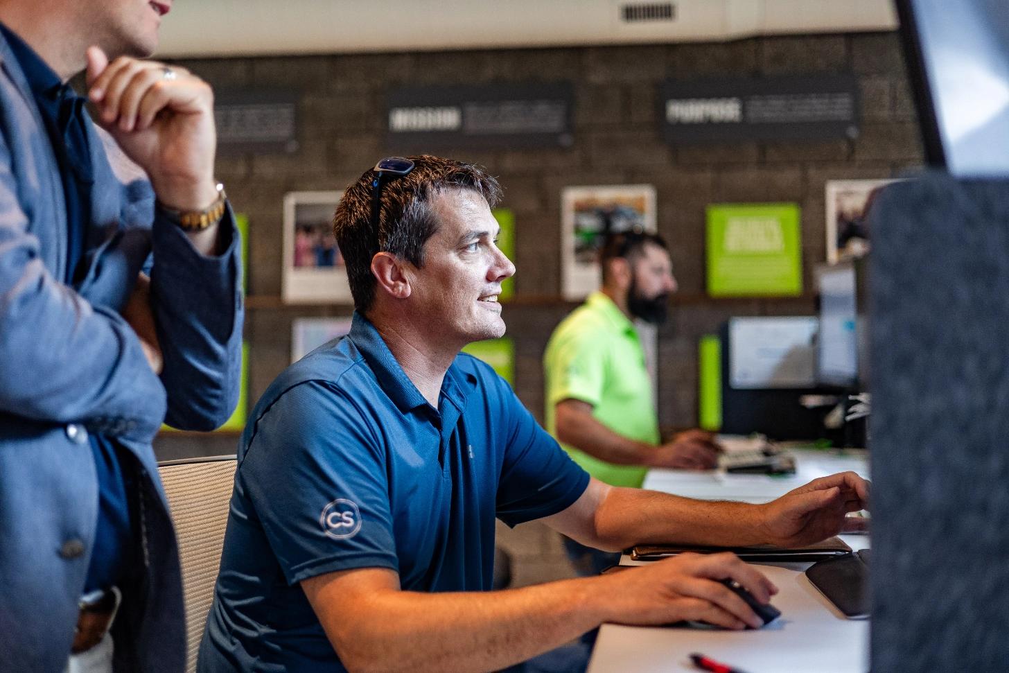 John Gibson working at computer with Brent looking over his shoulder