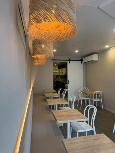 Finished Good Eats Mooloolaba seating room with rattan pendants, LED banquette and cafe tables